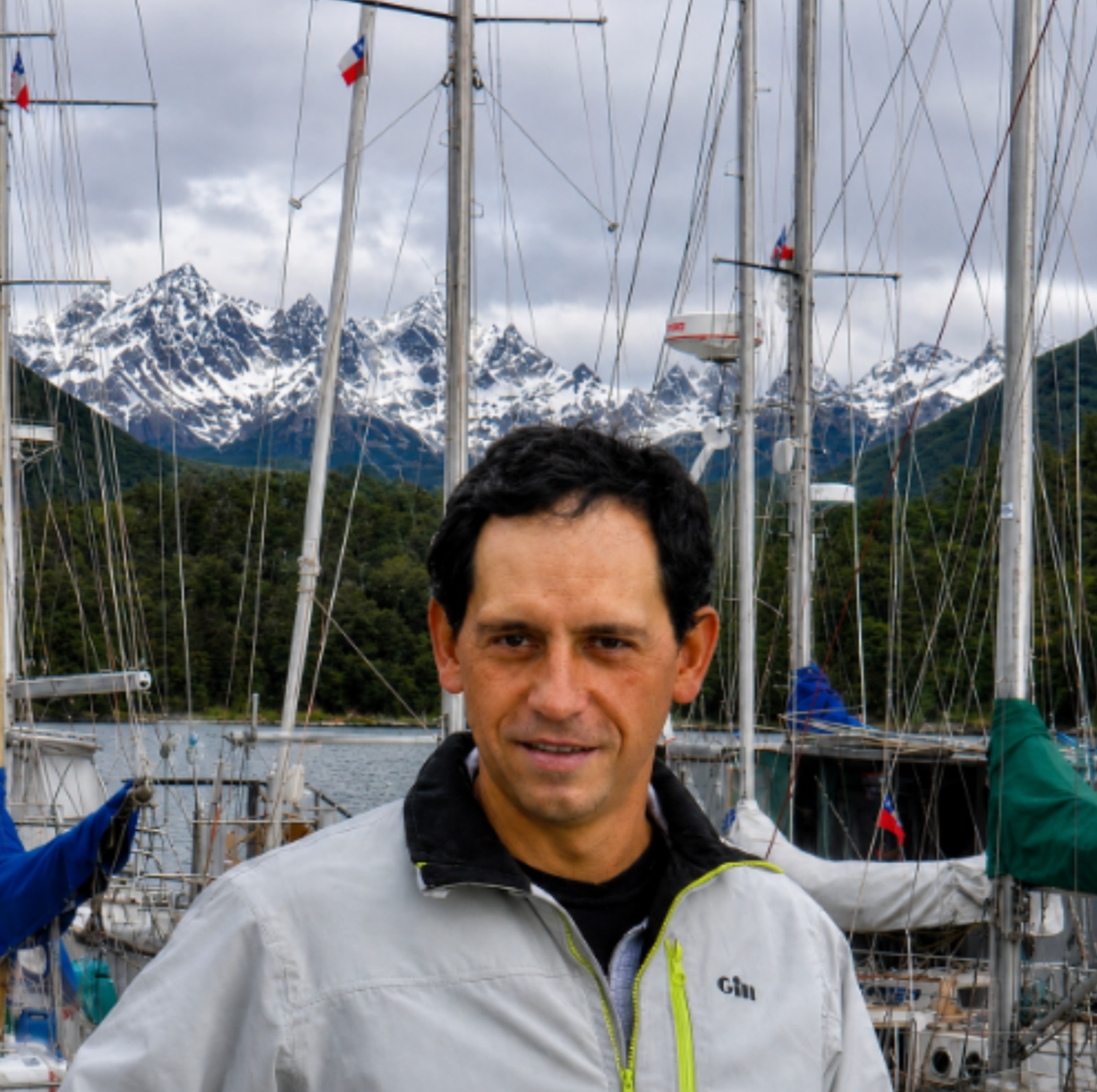 Carlos at the marina with snow-covered mountains in the background